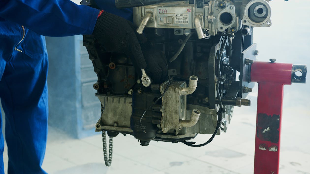 Close-up of a mechanic using a wrench to repair a car engine in a workshop setting