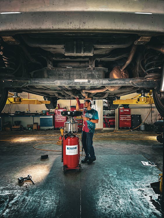 Mechanic working under a car repairing suspension components